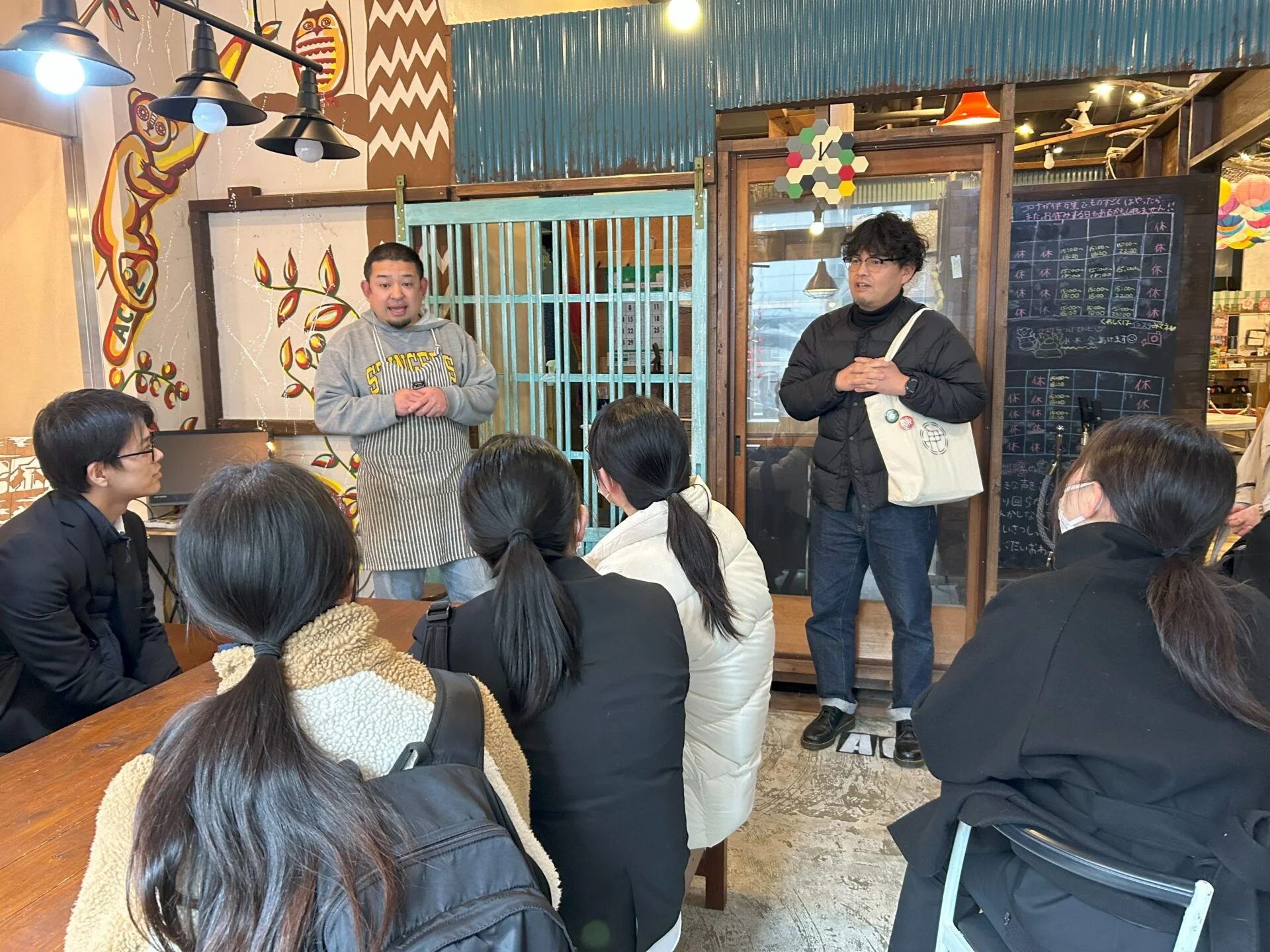 ガイドとツアー客が商店街を歩く様子